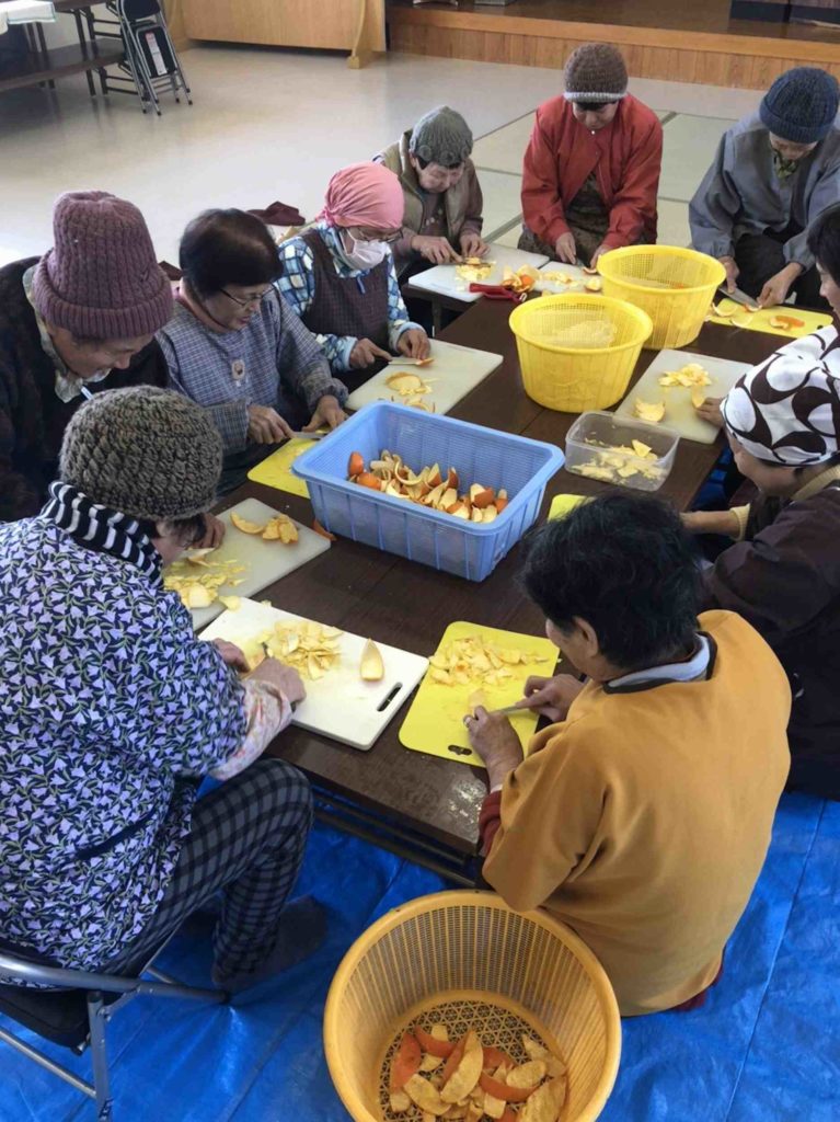 柑橘の皮をむく老人たち