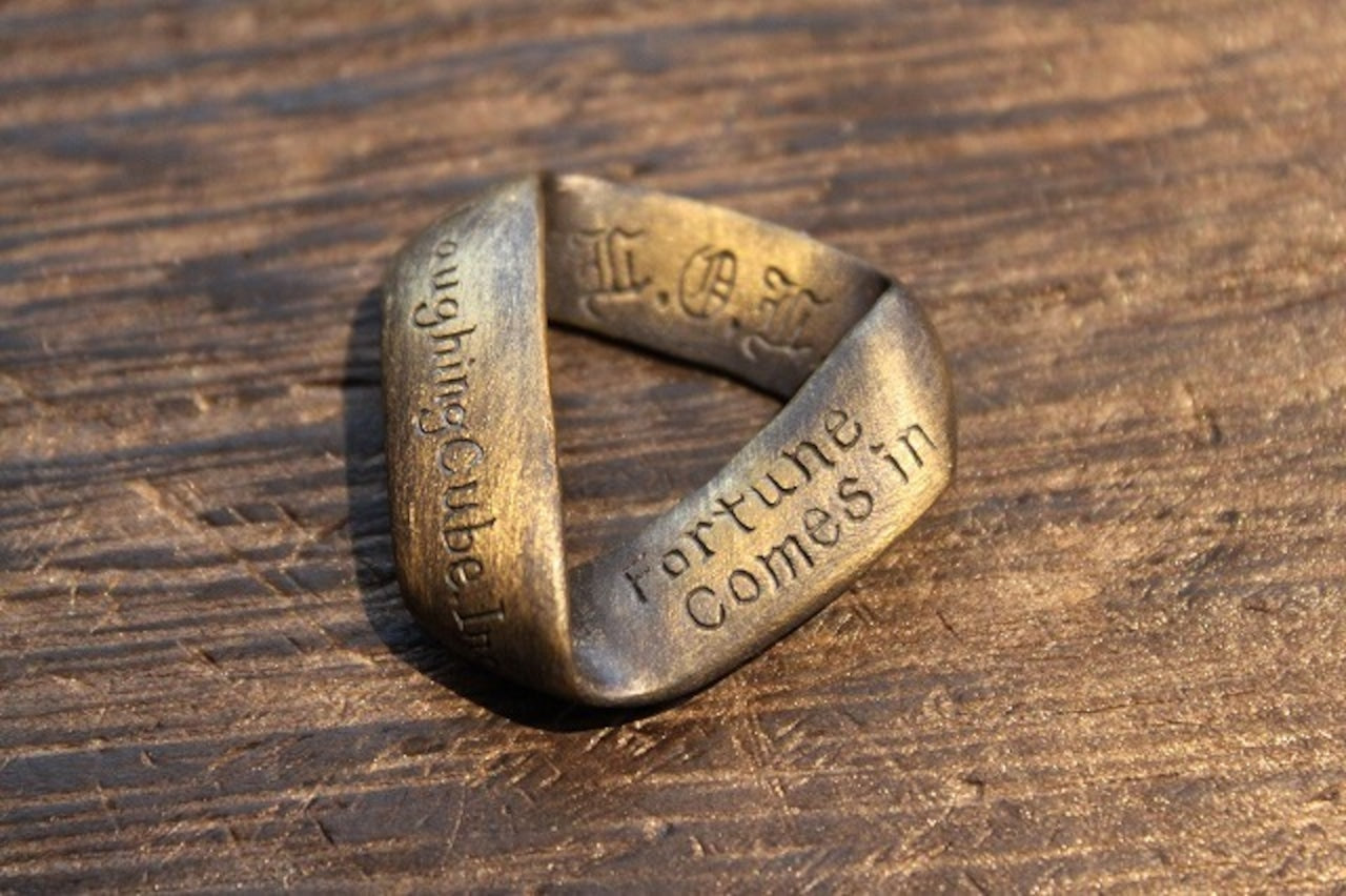 Laughing Cube Incの刻印と「fortune comes in」の英語メッセージが入った、アンティーク調の真鍮風リング。重厚感のあるデザインのL.O.L.オリジナルアクセサリー