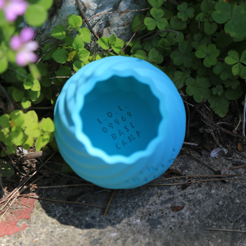 THE KOSHIKI ISLANDの文字が彫られた、水色のマットな質感の多角形カップ。ひねりのある立体形状が特徴で、09969。jpによる甑島オリジナルグッズの画像10