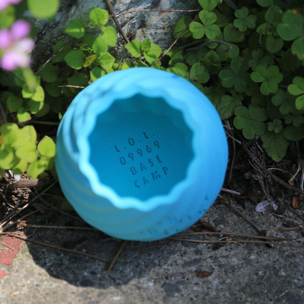 THE KOSHIKI ISLANDの文字が彫られた、水色のマットな質感の多角形カップ。ひねりのある立体形状が特徴で、09969。jpによる甑島オリジナルグッズの画像3