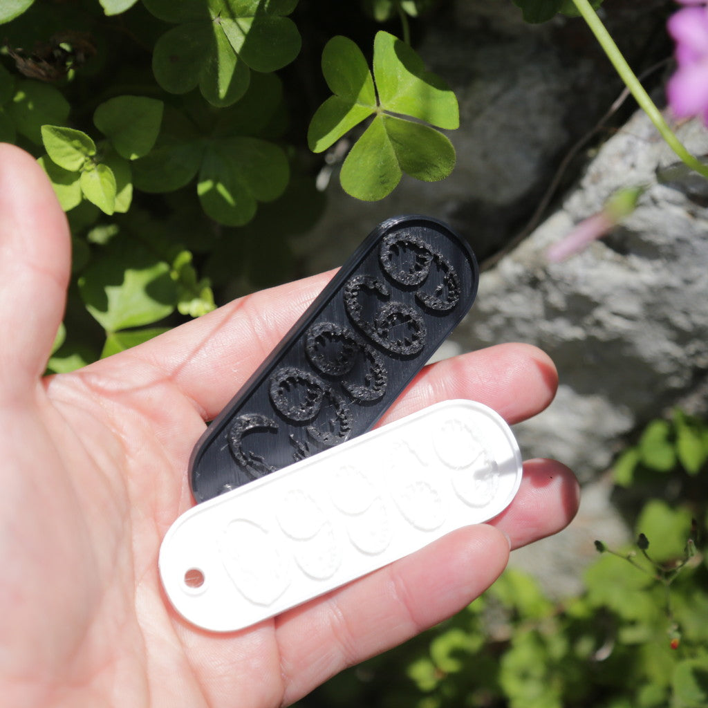 09969のロゴが立体的に彫られた白と黒の楕円型キーホルダー。シンプルでコンパクトなデザインが特徴の、甑島オリジナルグッズの画像1