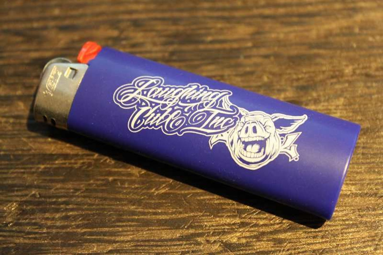 Laughing Club Incのロゴとブタのイラストがプリントされた青いライターの画像。