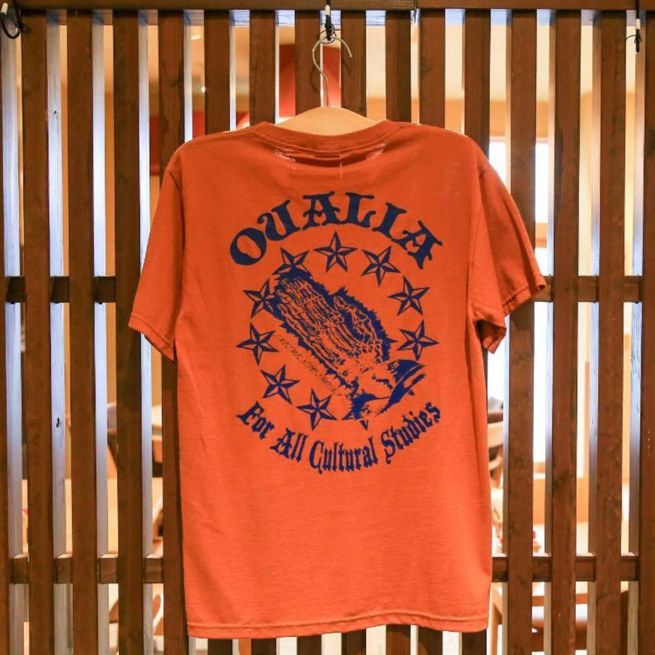 QUALIAロゴ入り赤茶Tシャツ｜バックに星とグラフィックがデザインされたストリート系プリントTシャツ