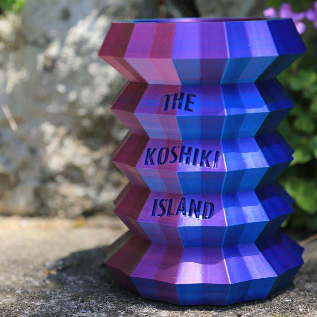 THE KOSHIKI ISLANDの文字が彫られた、光沢のあるグラデーションカラーの多角形カップ。甑島の企業09969.jpが手がけるオリジナルグッズの画像3