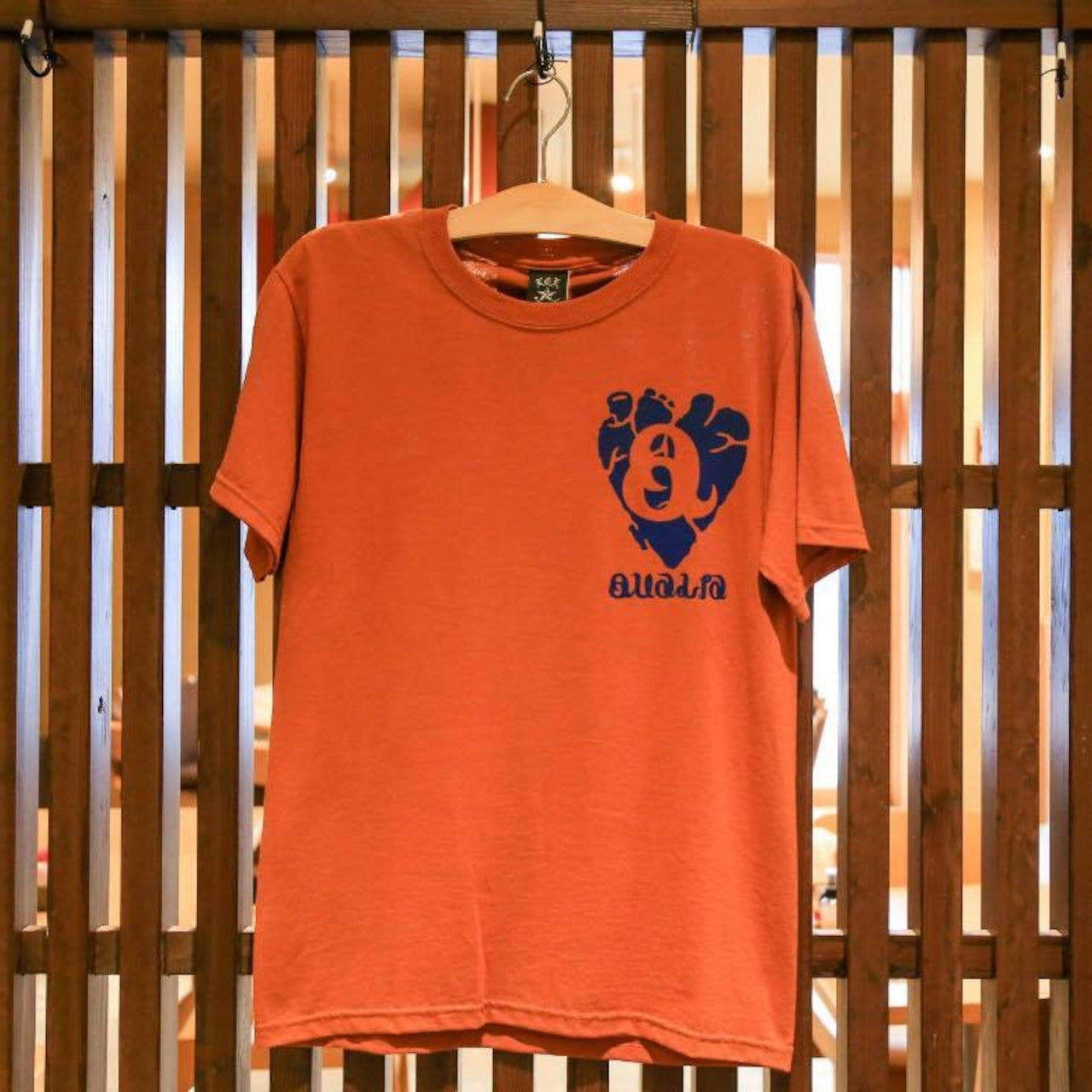 QUALIAロゴ入り赤茶Tシャツ｜バックに星とグラフィックがデザインされたストリート系プリントTシャツ画像3
